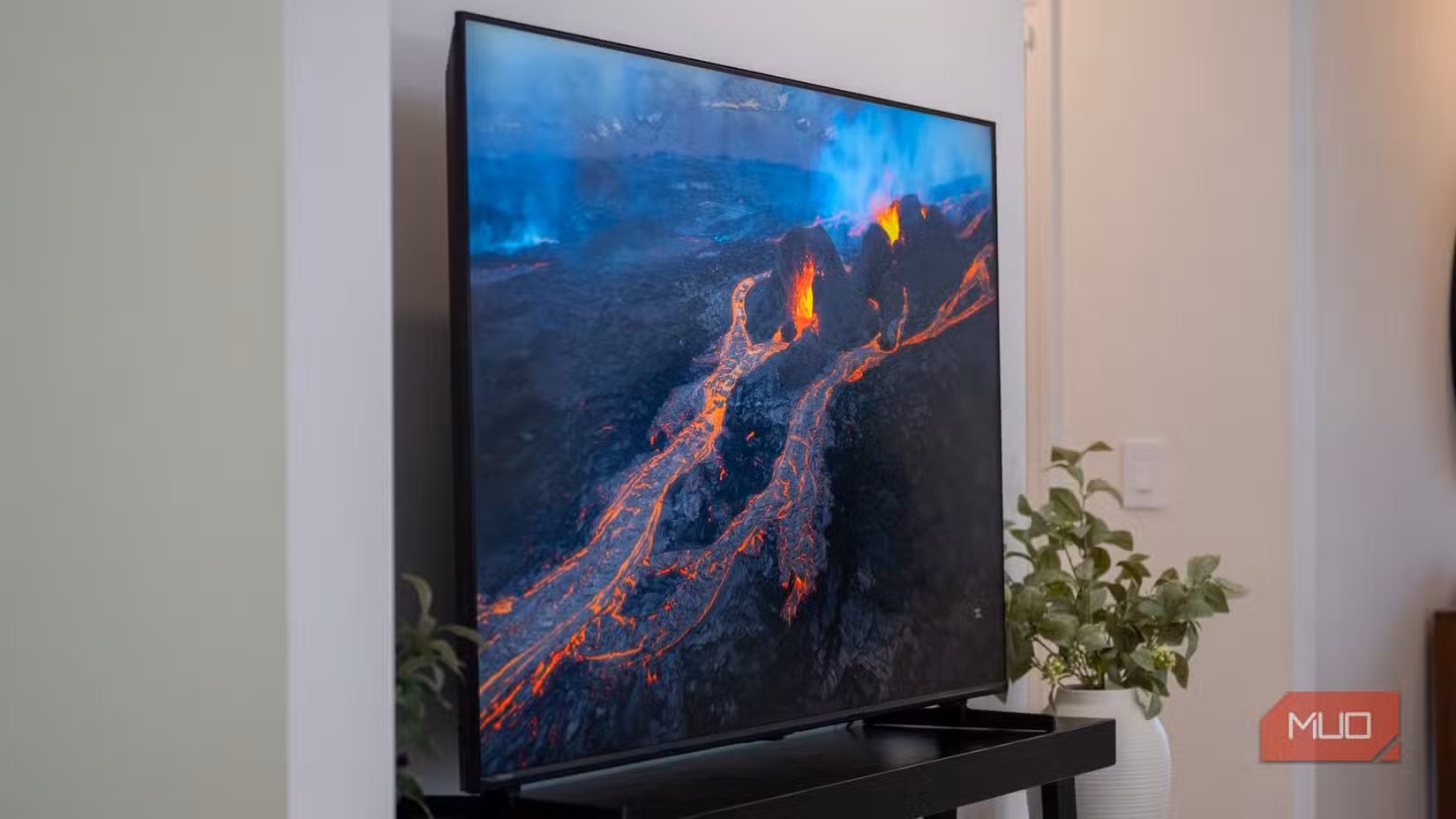 The Hisense U6SF Pro displaying a dramatic aerial view of glowing orange lava flows from an active volcano.