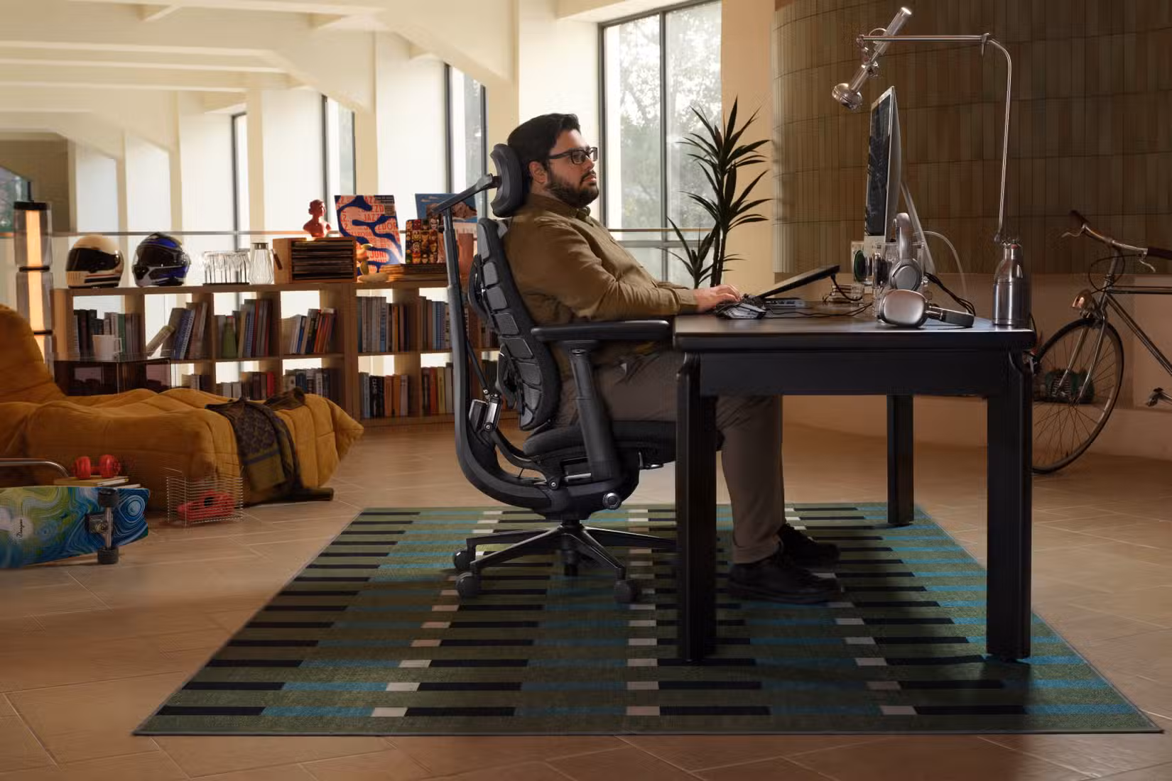 Side view of a man sitting at his desk in a LiberNovo Maxis chair
