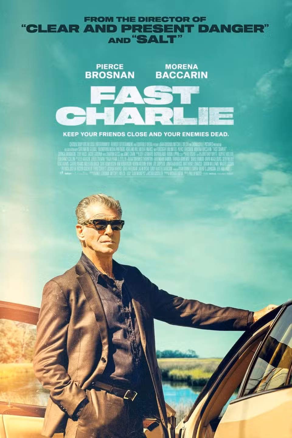 Fast Charlie Movie Poster - man standing against teal sky backdrop, hand on car looking outward