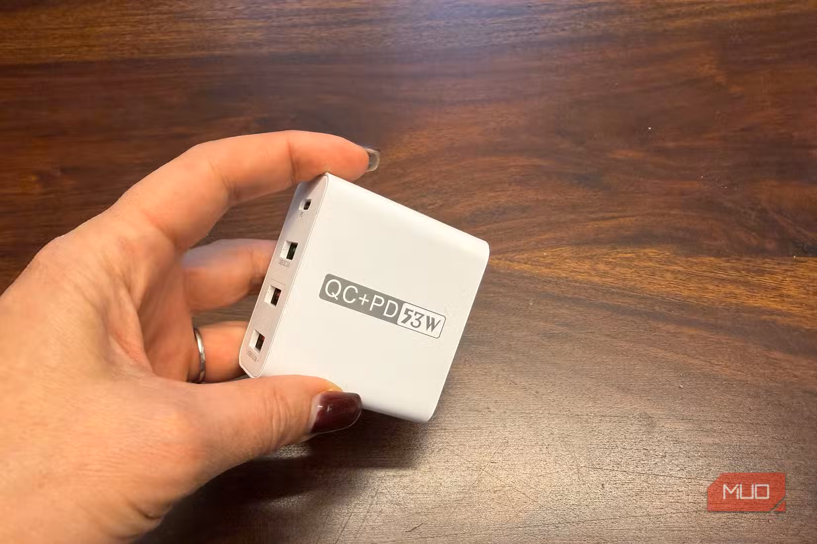 A hand holding a charging brick.