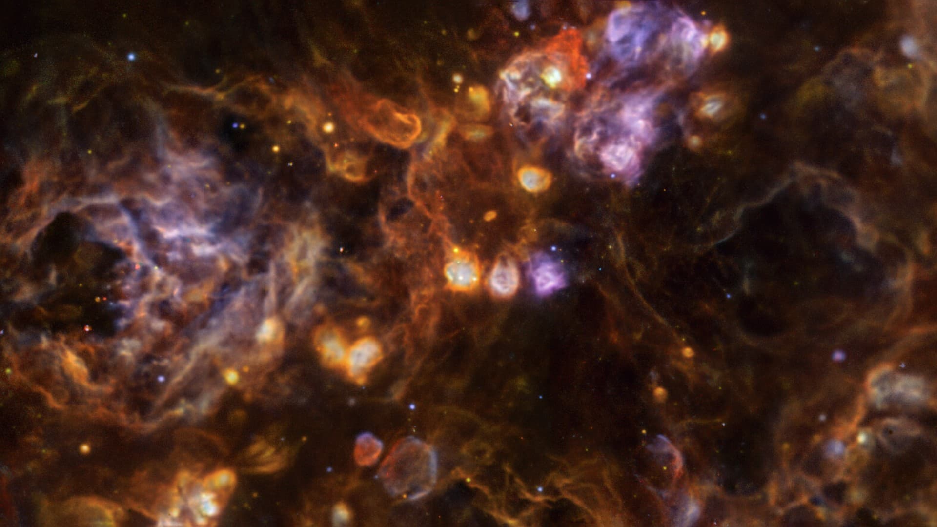 swirls and clouds of rainbow colors on a black background