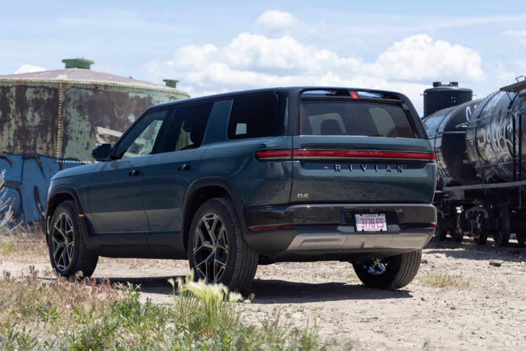 A green Rivian R2 seen from the rear 3/4s