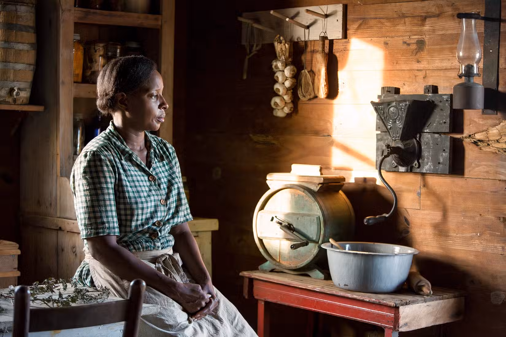 A woman sits down in Mudbound.