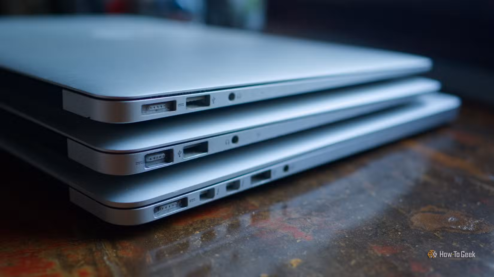 A stack of old MacBook Air and MacBook Pro laptops.