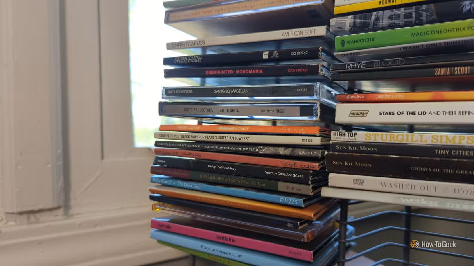 Several albums on a wire rack CD holder.