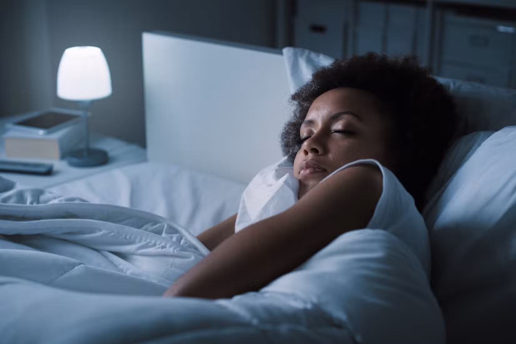 A woman sleeping in bed at night.