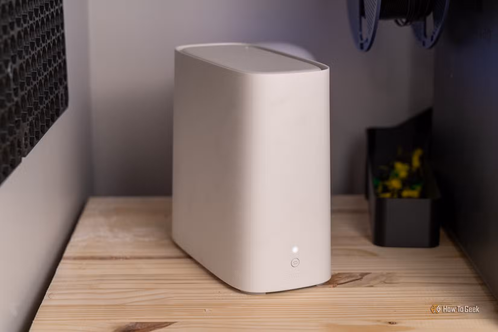 A white AT&T BGW320 Wi-Fi 6 router on a wooden shelf between two desktop towers.