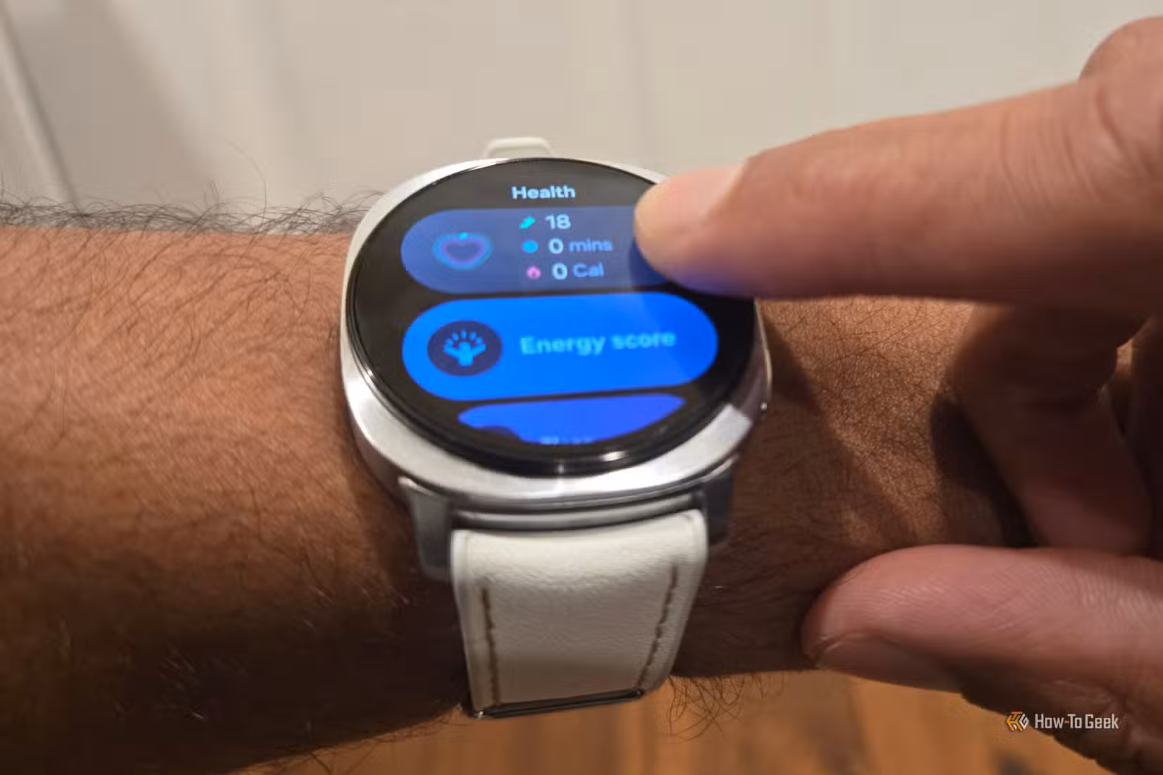 Finger tapping the bezel on a Samsung Galaxy Watch 8