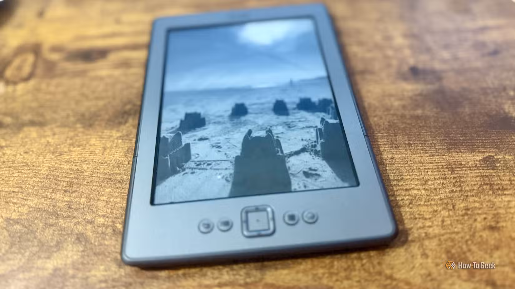 A Kindle 4 displaying a beach photo as the screen saver.