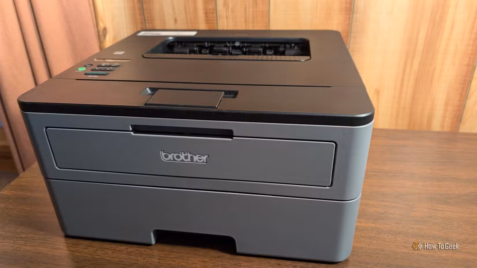 A Brother monochrome laser printer sitting on a desk.
