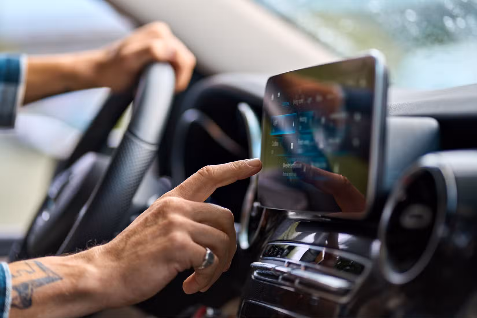 Hand reaching out to operate a touch screen.