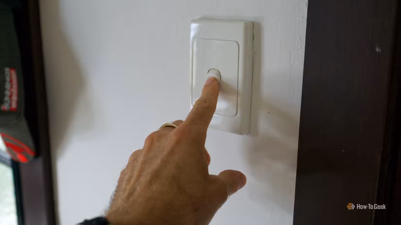 Pressing a dumb light switch to turn on a smart light bulb.