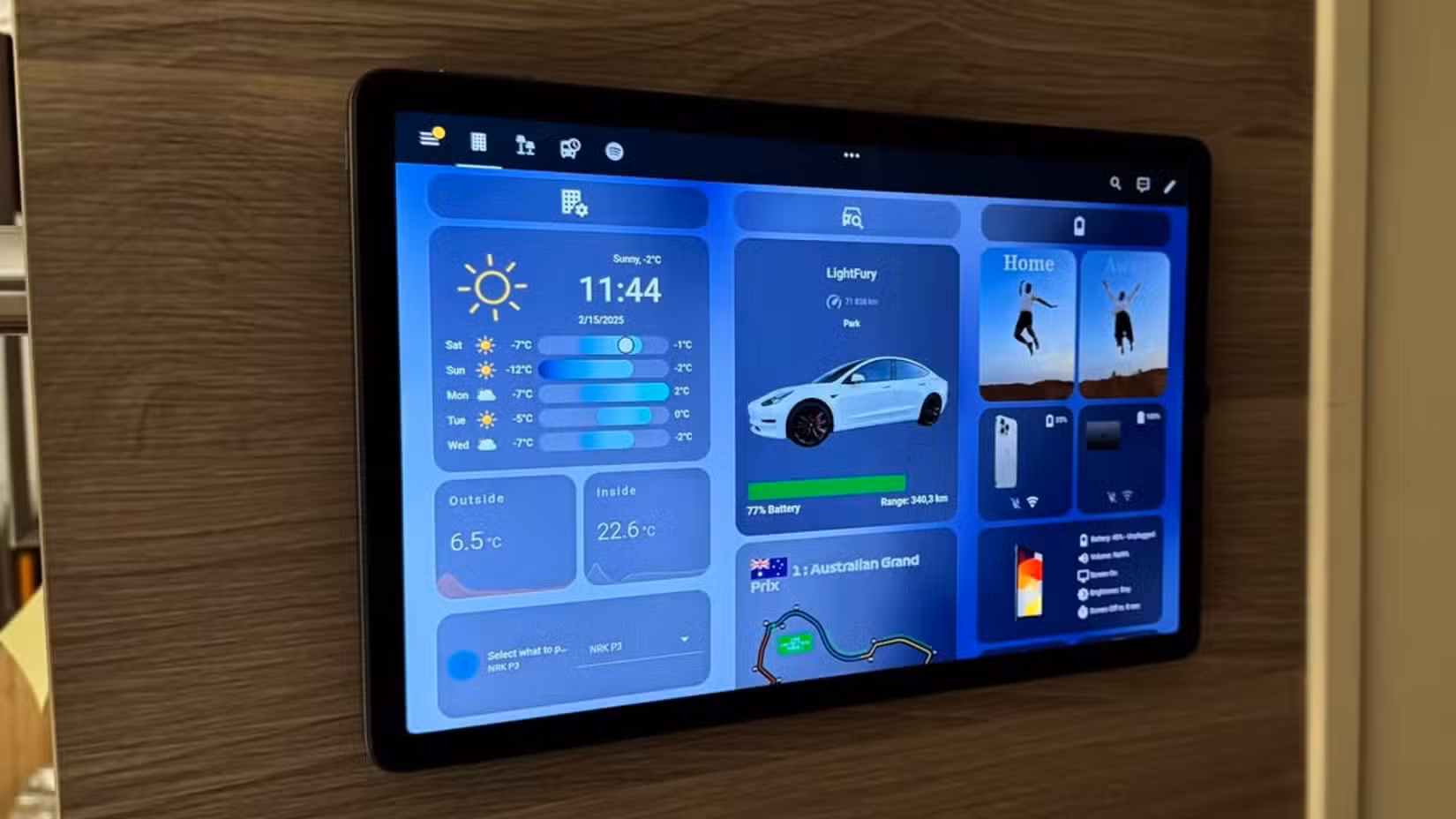 A tablet mounted to the wall with a Home Assistant dashboard on it.