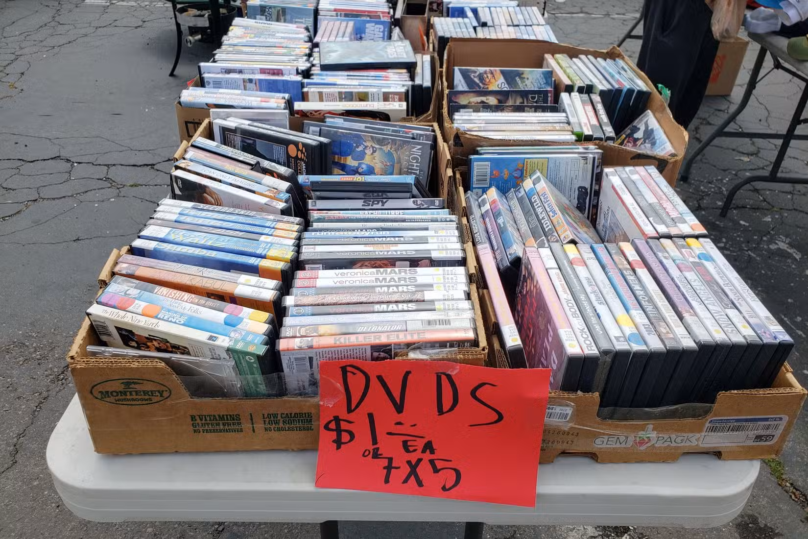 A view of several boxes filled with used DVDs.