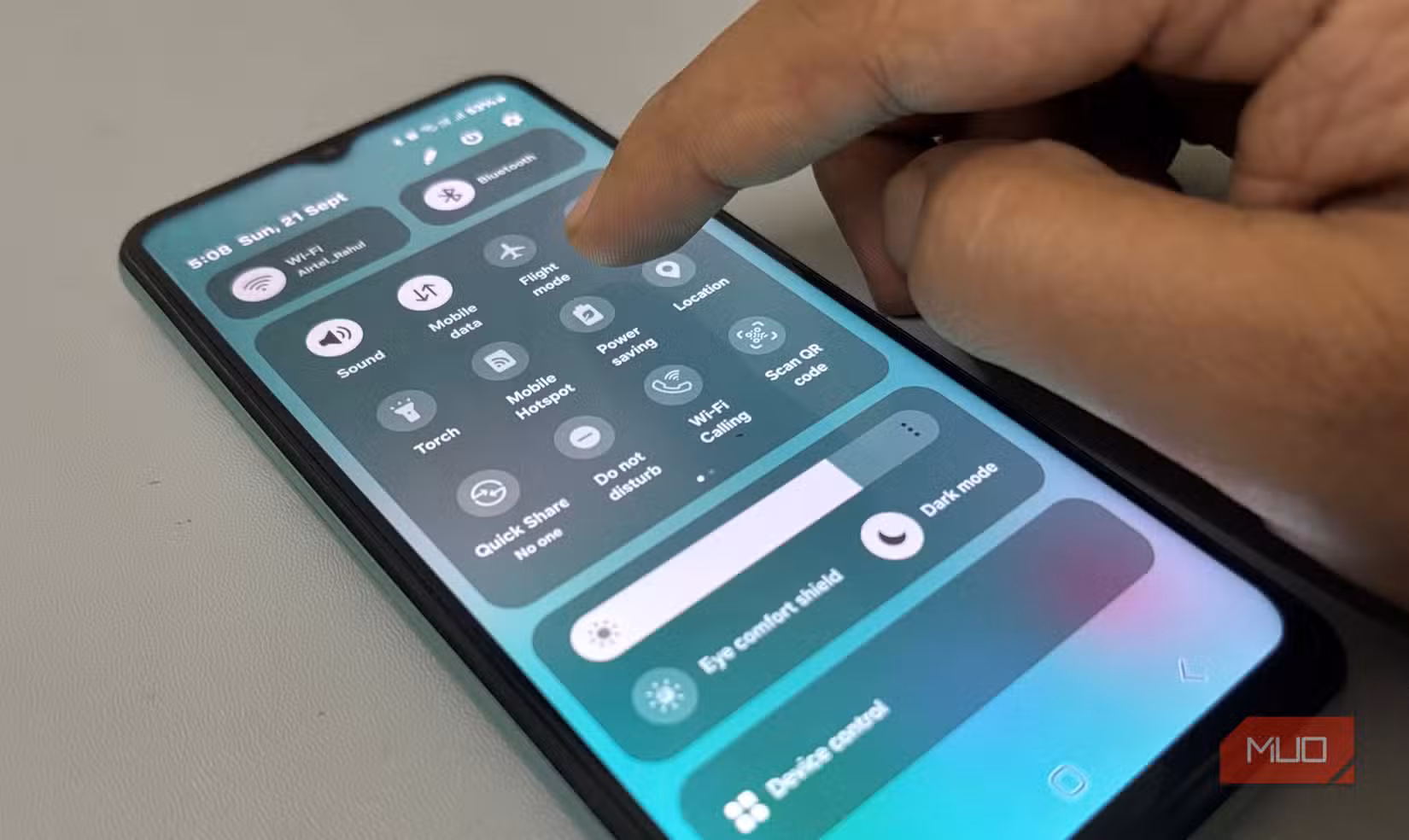 Finger tapping Quick Settings panel on Samsung phone screen
