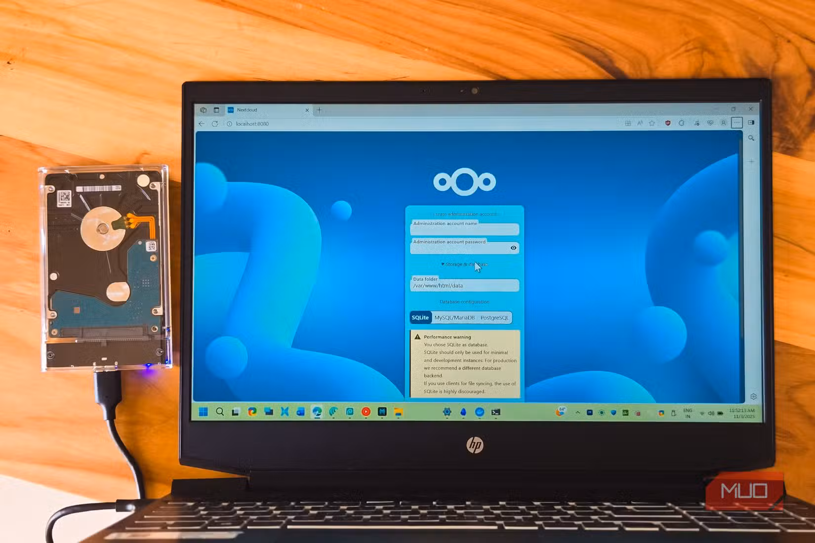 NextCloud login open on a HP laptop kept on a wooden table with an external HDD connected