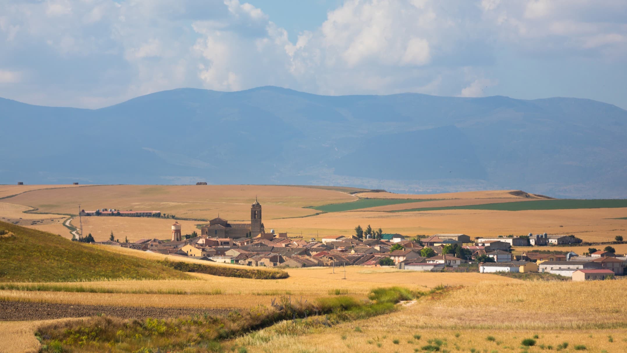 rolling countryside with a small village in the distance.