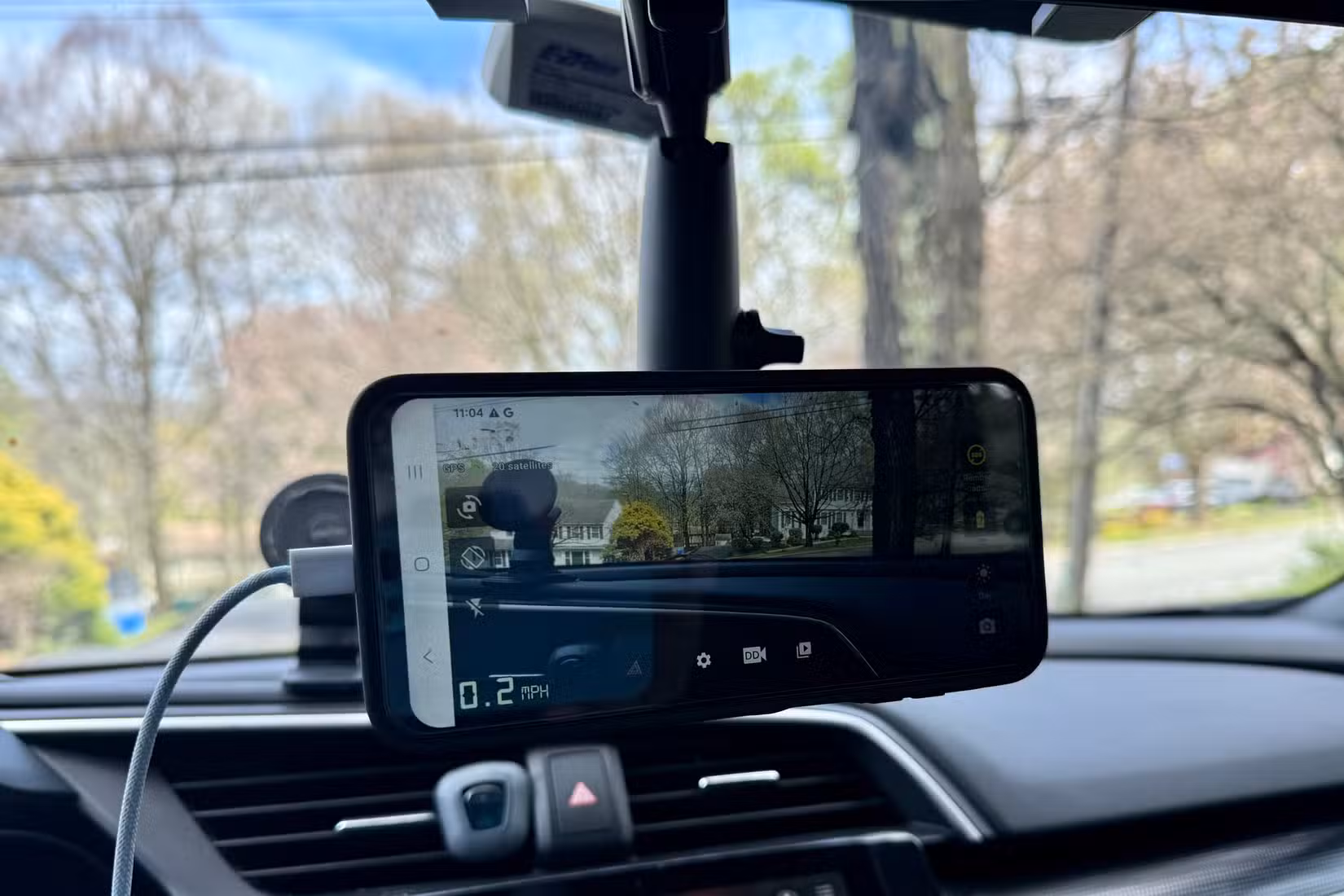 Phone magnetically mounted from the rear-view mirror in the car.