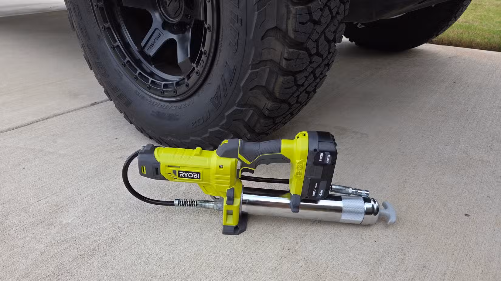 Ryobi grease gun by a truck tire.