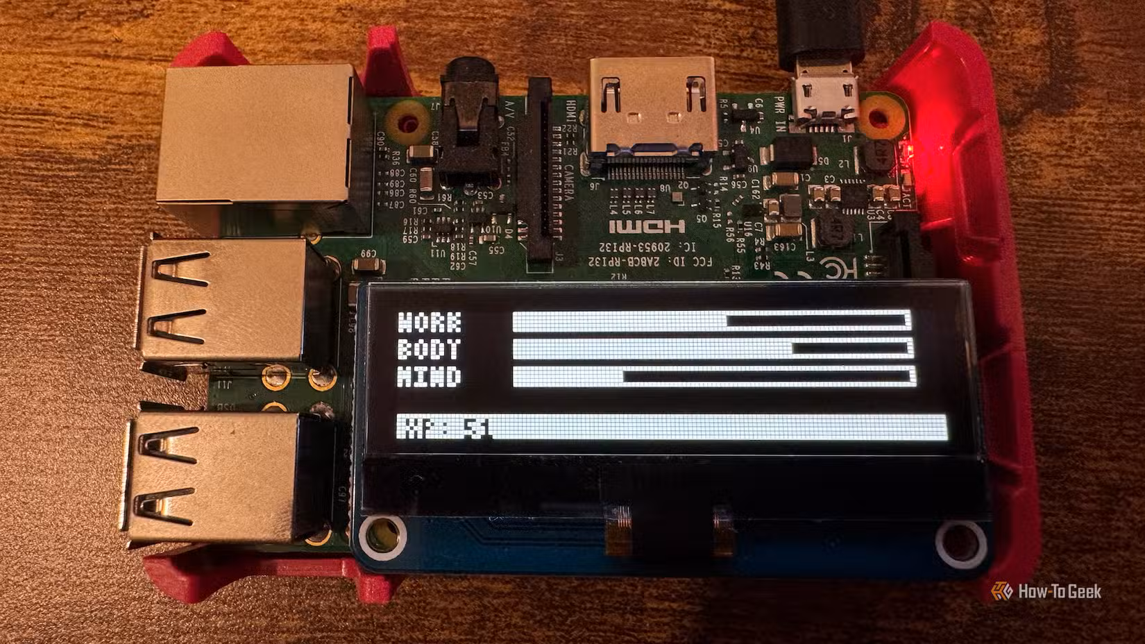 A Raspberry Pi with an OLED screen displaying the stats for a Tamagotchi character.