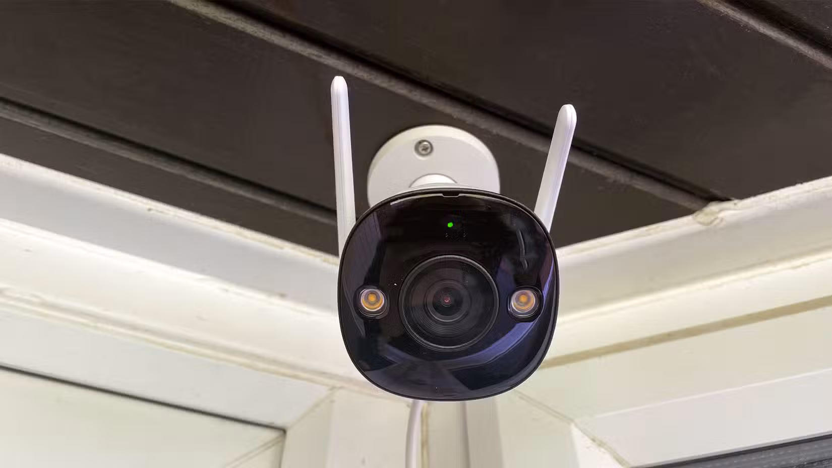 Defender Guard Pro 2K Wi-Fi Security Camera on Black Wooden Porch Front Angle