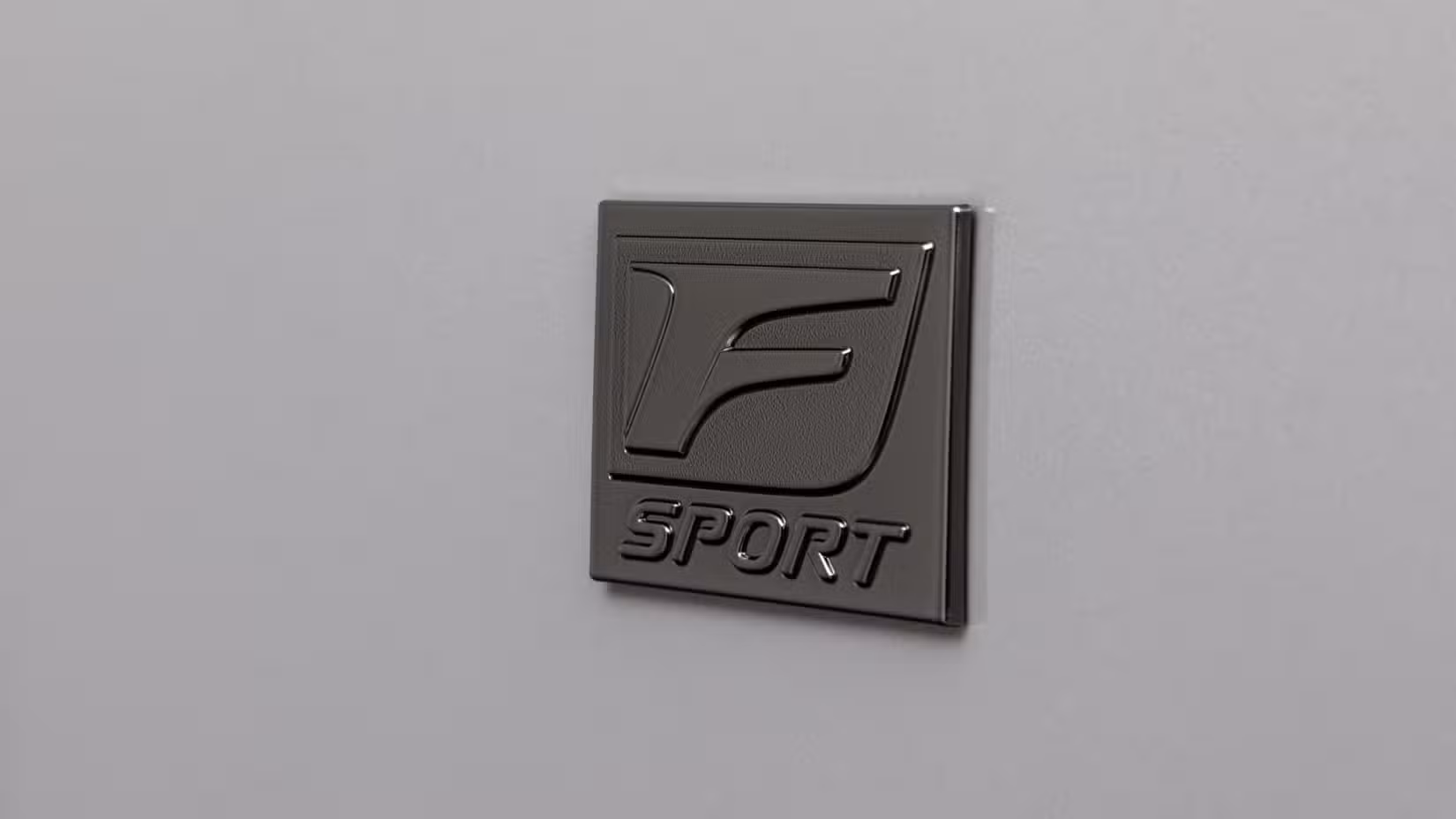 Close-up shot fo the 'F Sport' badging on a gray 2026 Lexus IS 350.