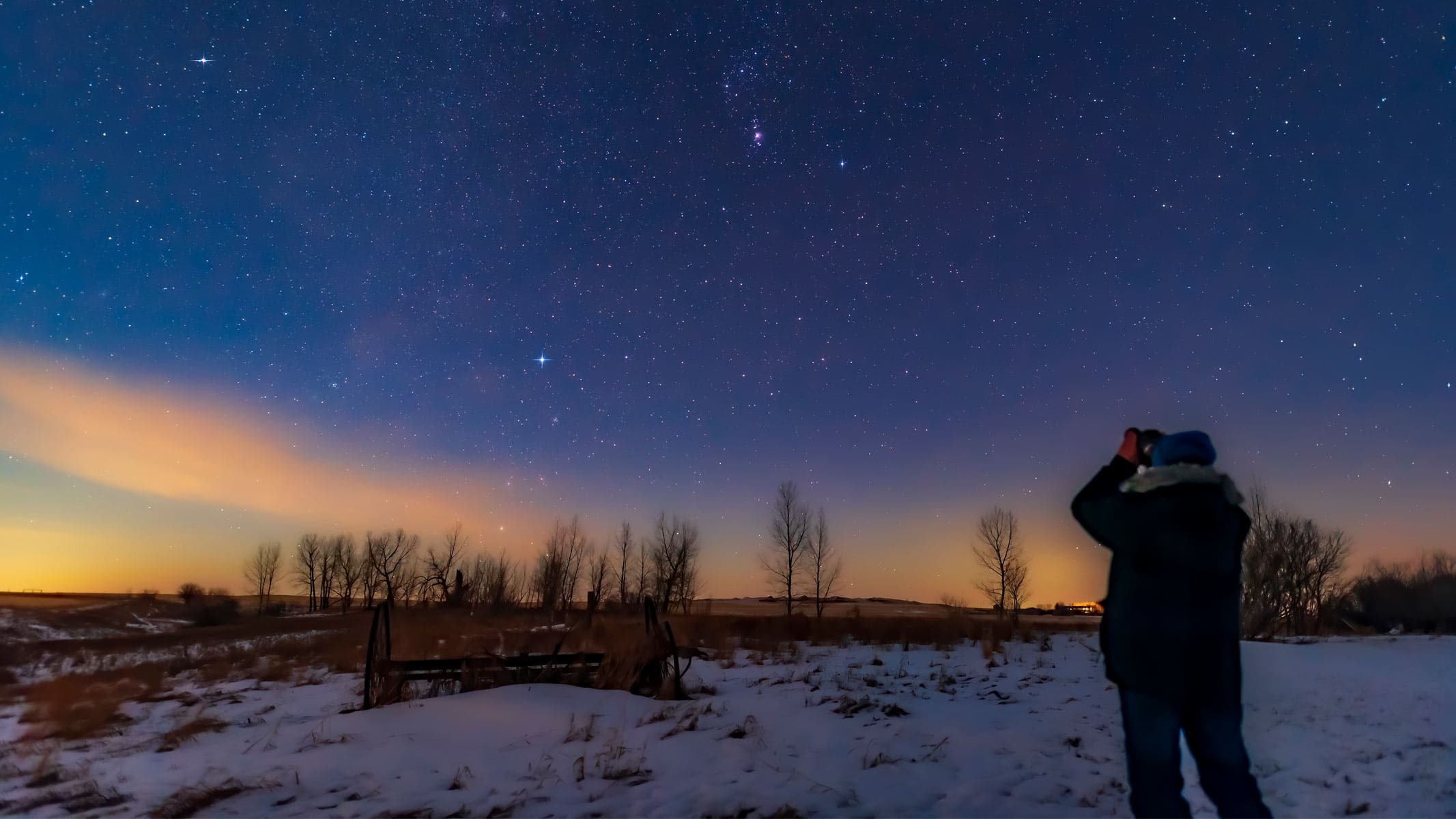 Astronomer using binoculars to view the Orion Nebula