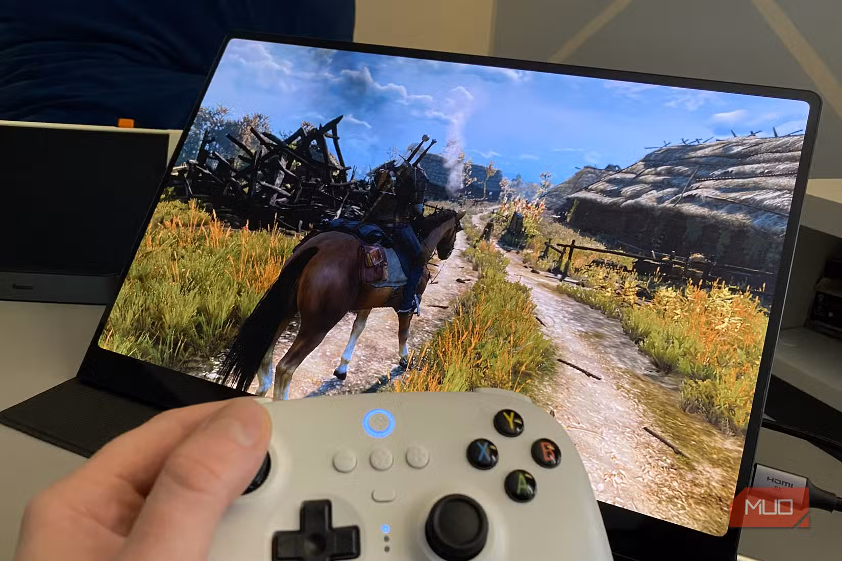Steam Deck hooked up to a portable OLED monitor playing the Witcher 3