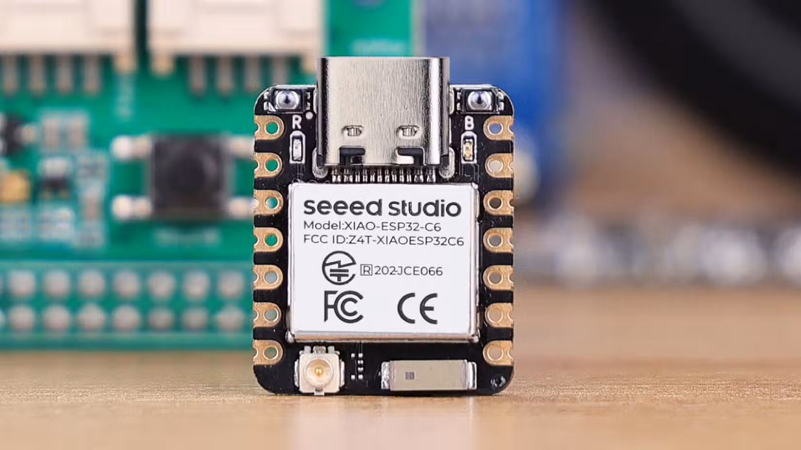 Seeed Studio XIAO ESP32C6 with blurred out microelectronics in the background.