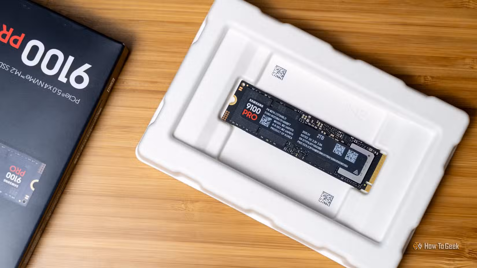 The Samsung 9100 PRO NVMe SSD sitting in its box next to retail packaging.