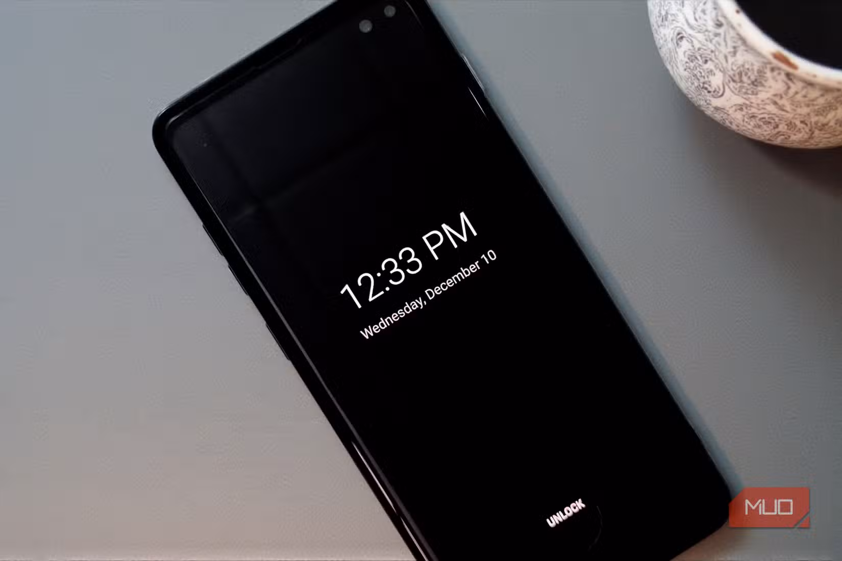 A smartphone with always-on-display lying on a desk.