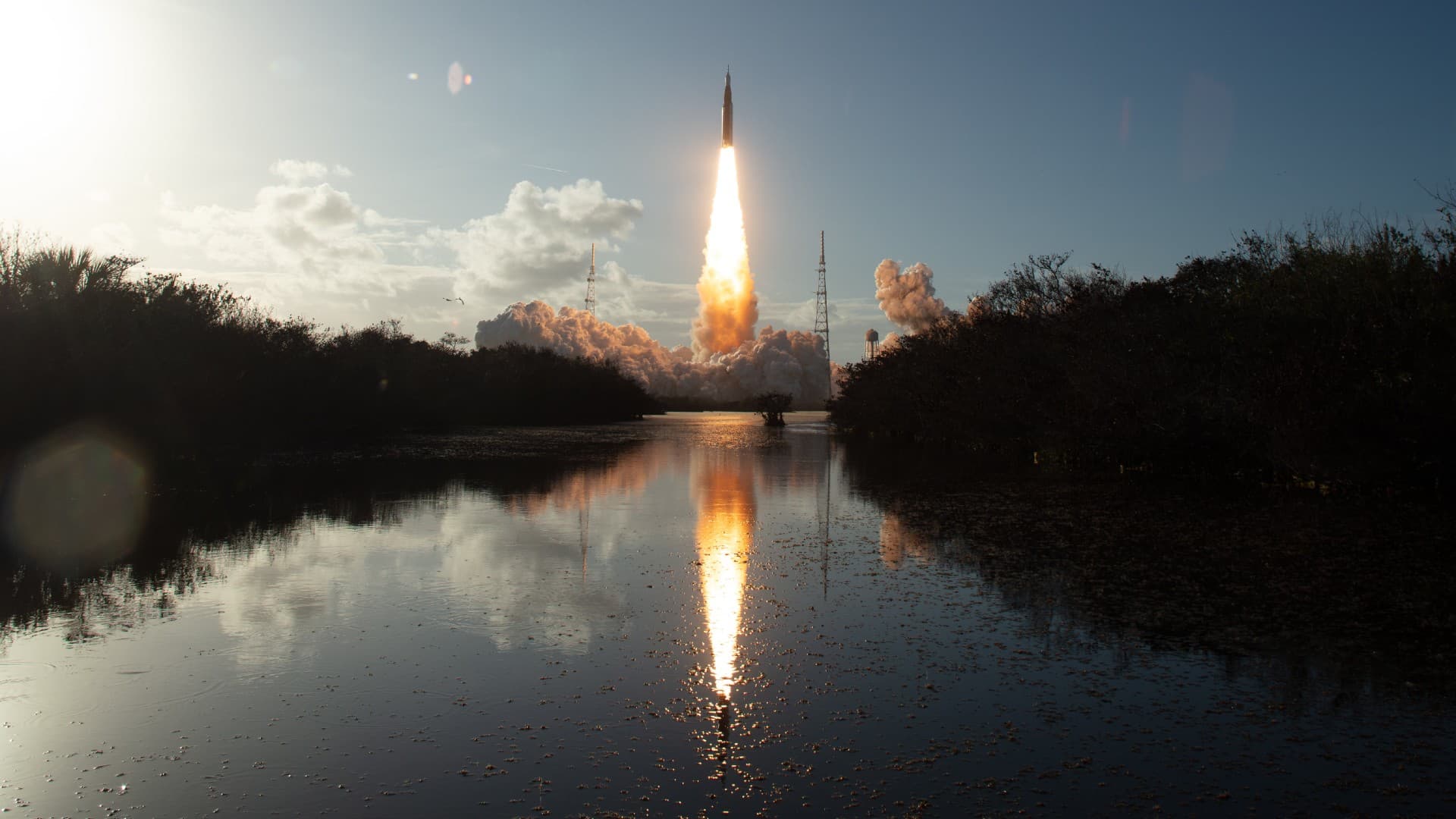 a rocket launches above a plume of fire
