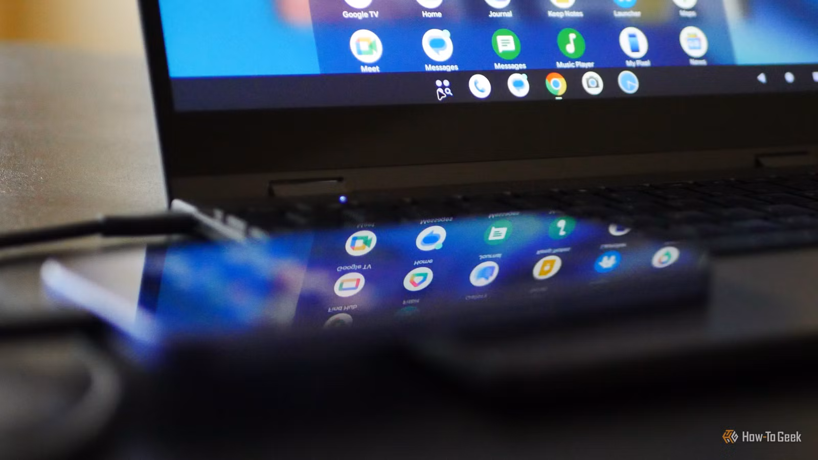 Google Pixel 10a with Pixel Desktop displayed on a lapdock in the background.