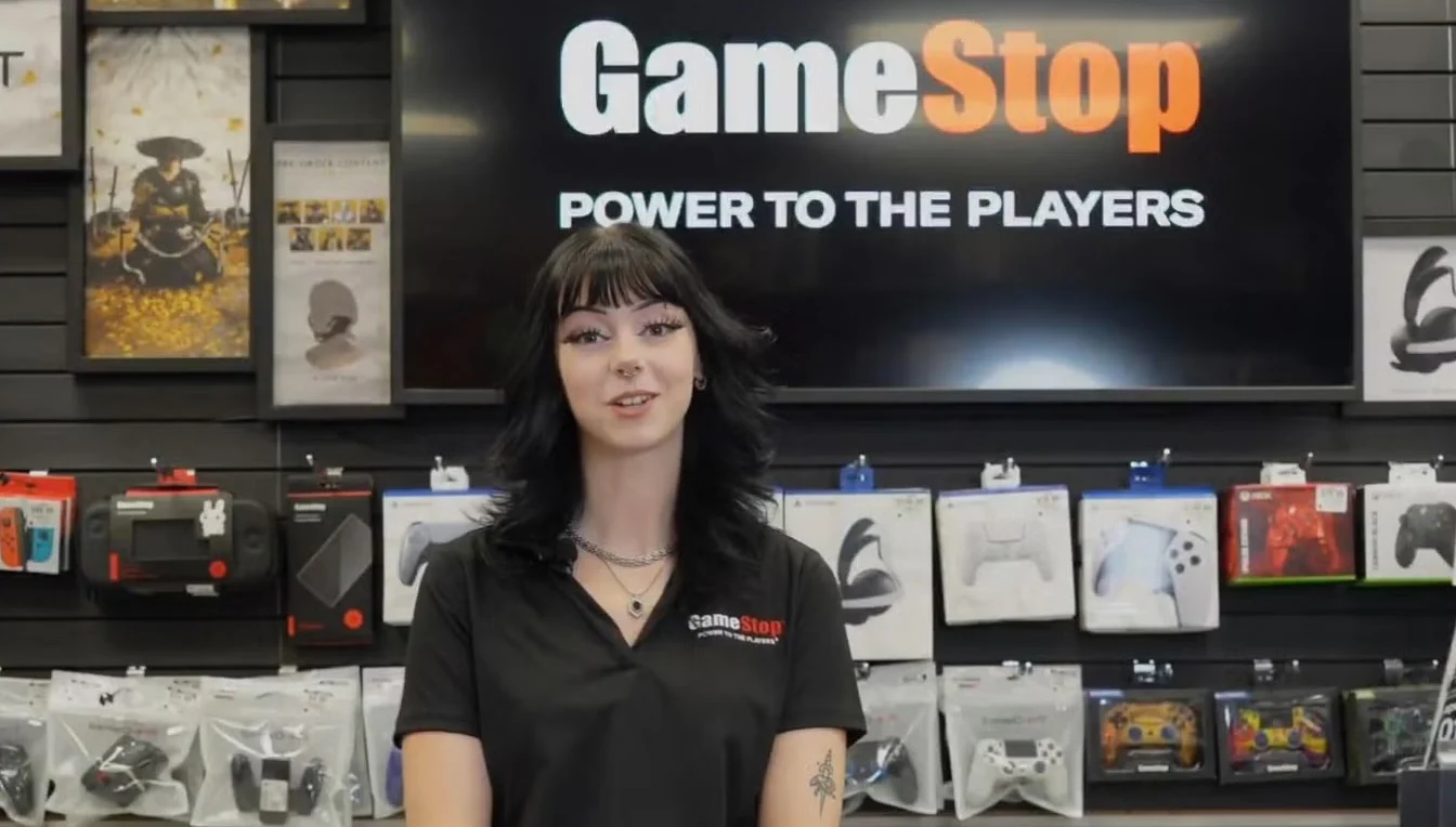 A woman stands behind the counter at GameStop.