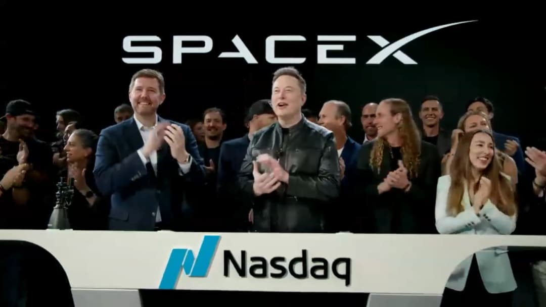 Elon Musk claps after SpaceX begins trading on the Nasdaq
