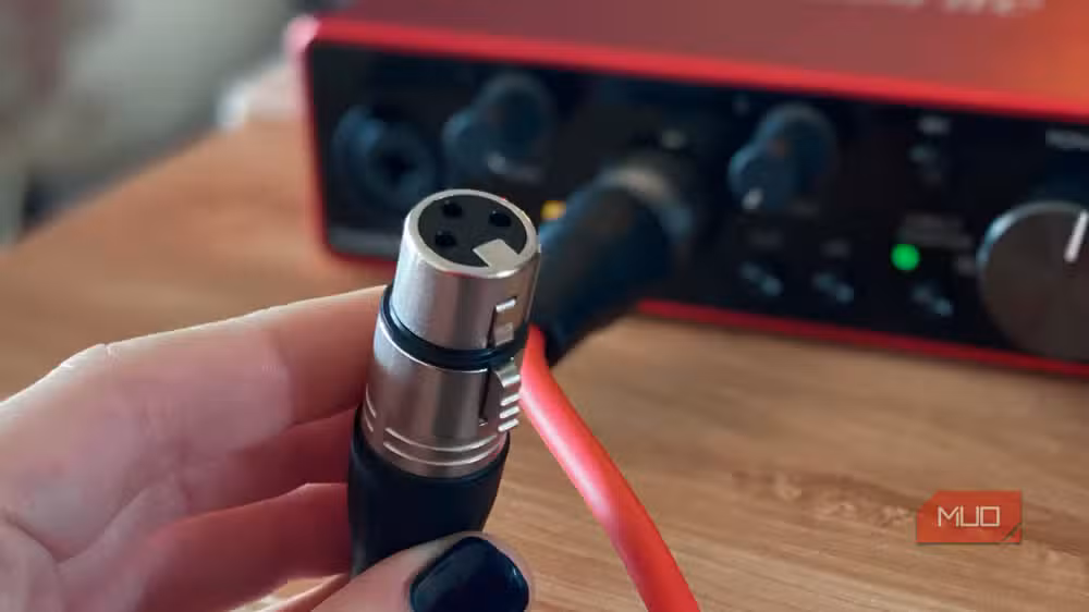 كابل XLR بثلاثة دبابيس متصل بمايكروفون احترافي في استوديو تسجيل