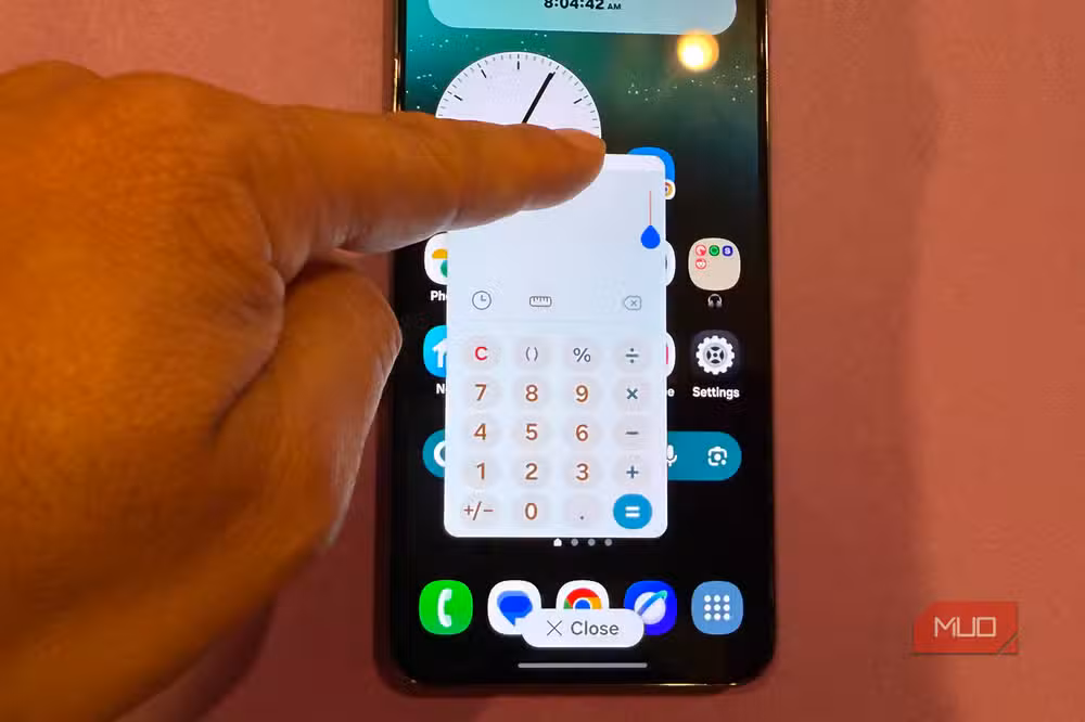 مستخدم يحمل هاتف Samsung Galaxy ويستعد للنقر على ظهره بإصبعه السبابة