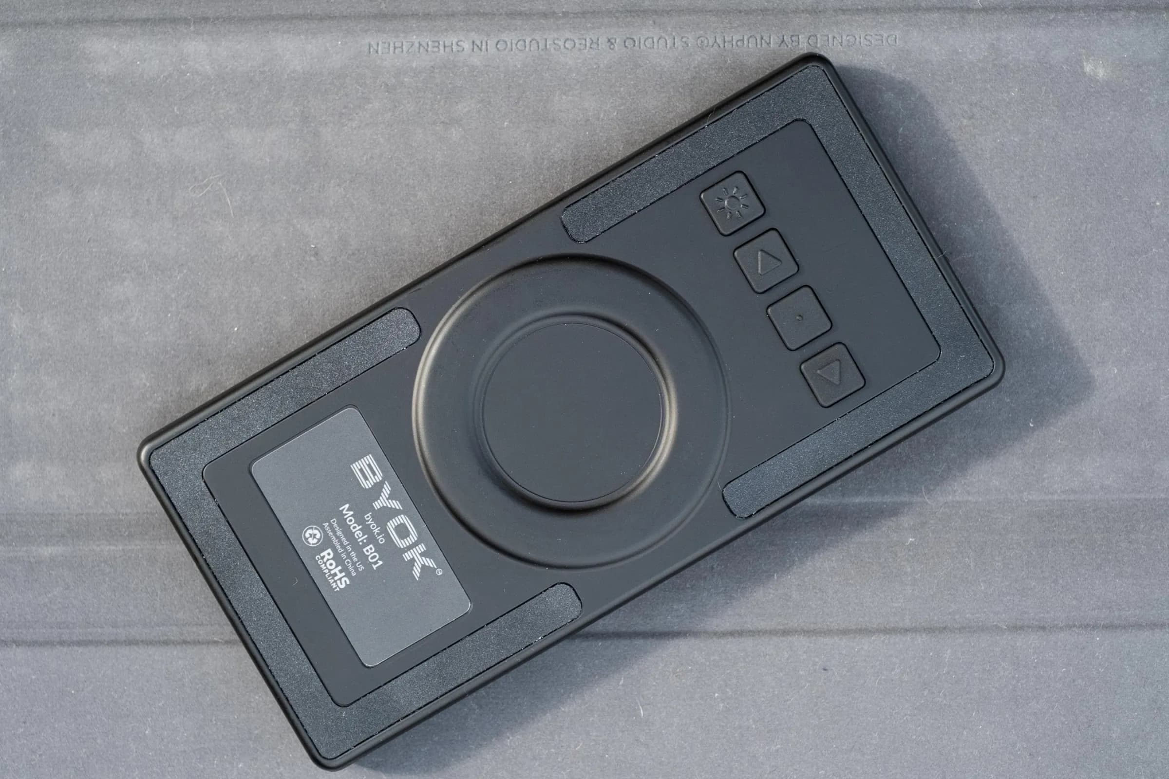 The back of the BYOK showing the company logo, a button for toggling the backlight, and buttons for navigating the interface when a keyboard isn’t connected.