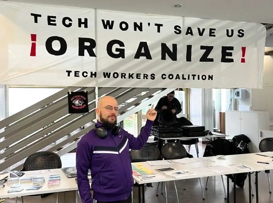 photo of simone robutti pointing to tech workers coalition sign that says tech won