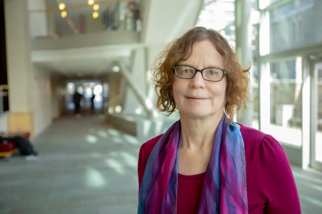 photo of kate bronfenbrenner standing in an atrium