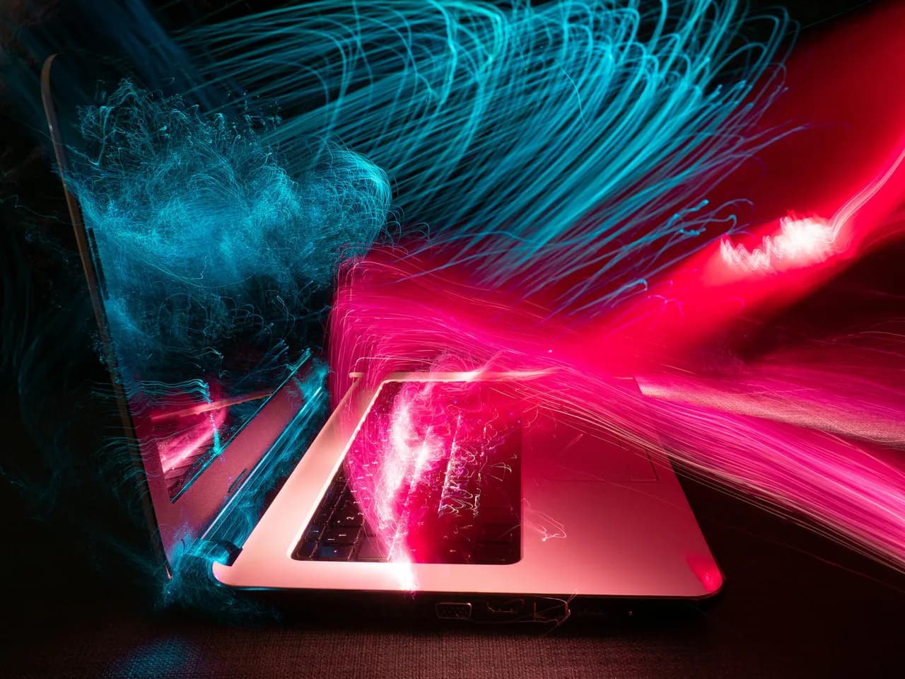 Hacker silhouette against red and blue lighting representing cyber threat